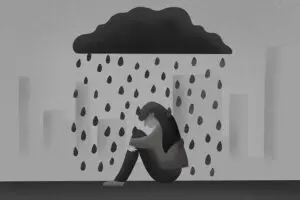 A grayscale illustration of a person sitting on the ground, hugging their knees. A dark cloud hovers above them, raining large drops. The background depicts indistinct city buildings, conveying a sense of sadness or loneliness.