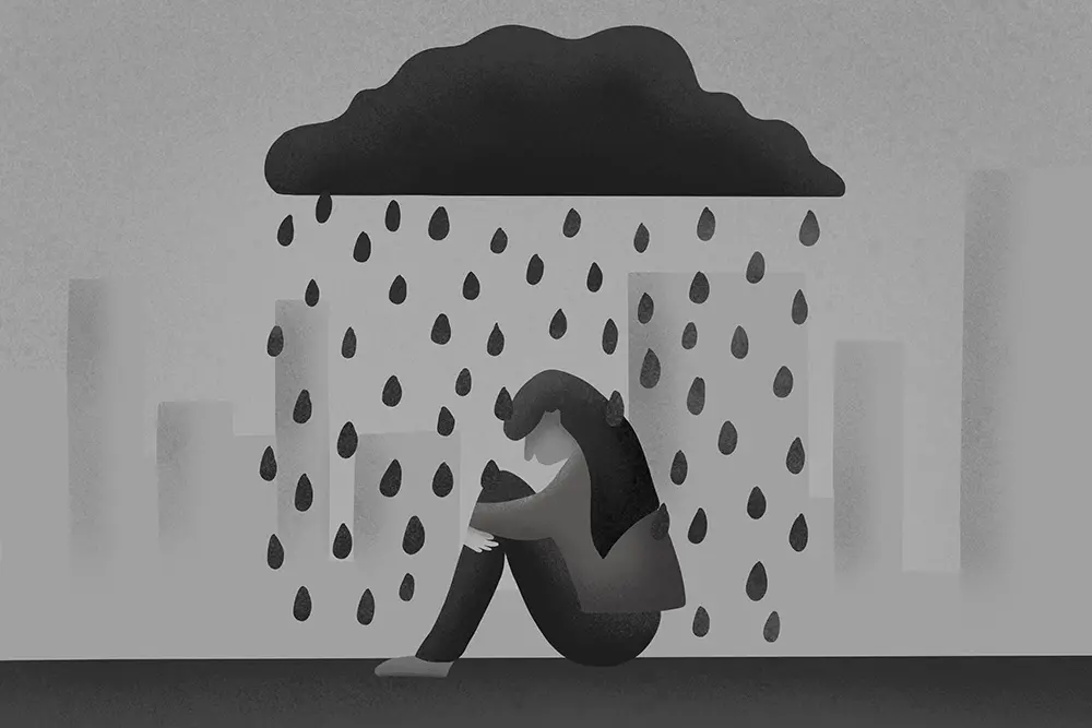 A grayscale illustration of a person sitting on the ground, hugging their knees. A dark cloud hovers above them, raining large drops. The background depicts indistinct city buildings, conveying a sense of sadness or loneliness.